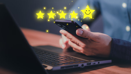 Man's hand using a smartphone and give five star symbol to increase rating of product and service concept, Customer service experience, testimonial and business satisfaction survey.の写真素材