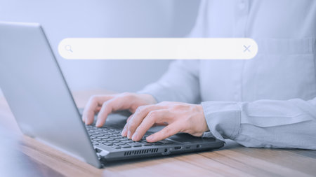 Businessman's hand working with computer laptop on desk in home. Searching Browsing Internet Data Information with blank search bar. Search Engine Optimization SEO Networking Concept.の写真素材