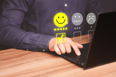 Man hand using computer laptop with popup five star icon for feedback review satisfaction service, testimonial. Customer service experience and business satisfaction survey.の写真素材