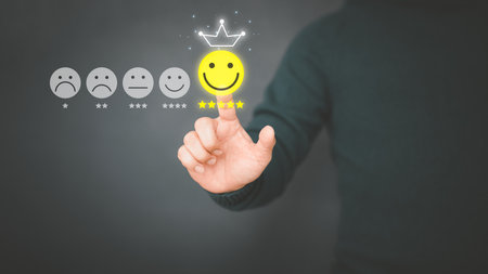 Man touching the virtual screen on the happy smiley face icon to give satisfaction in service. Rating very impressed. Customer service, testimonial and satisfaction concept.の写真素材