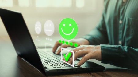 Man hand using computer laptop with popup five star icon for feedback review satisfaction service, testimonial. Customer service experience and business satisfaction survey.の写真素材
