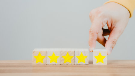Customer's hand selects a star icon on a wooden cube block with 5 Star Satisfaction. Best great business services rate the customer experience. Satisfaction Survey Concept.の写真素材