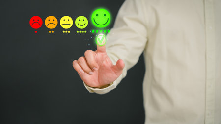 Man touching the virtual screen on the happy smiley face icon to give satisfaction in service. Rating very impressed. Customer service, testimonial and satisfaction concept.の写真素材