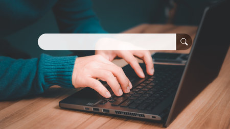 Mature man hand working with laptop computer on table in his home. Search the Internet with an empty search bar. Best SEO search networking, Searching browsing internet data information concept.の写真素材