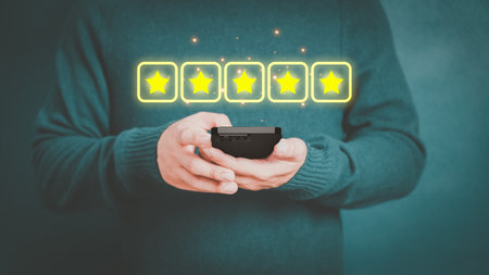 Man's hand using a smartphone and give five star symbol to increase rating of product and service concept, Customer service experience, testimonial and business satisfaction survey.の写真素材