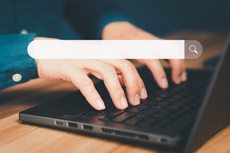 Mature man hand working with laptop computer on table in his home. Search the Internet with an empty search bar. Best SEO search networking, Searching browsing internet data information concept.の写真素材