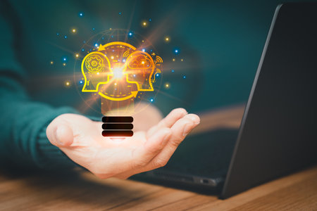 Man holding abstract light bulb icon while working on computer thinking and create new ideas, with technological innovation and creativity Ideas inspired by online technology innovation.の写真素材