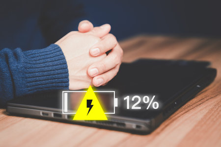 Young man is angry and frustrated when he learns that his the laptop computer's battery is dead and did not bring the charger adapter. No power battery.の写真素材