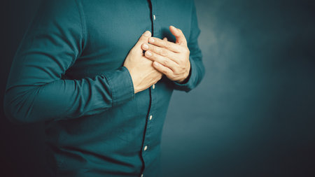 Adult man suffering from chest pain, Hand pressing on chest with painful expression, Severe heartache, Having heart attack.の写真素材