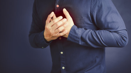Adult man suffering from chest pain, Hand pressing on chest with painful expression, Severe heartache, Having heart attack.の写真素材