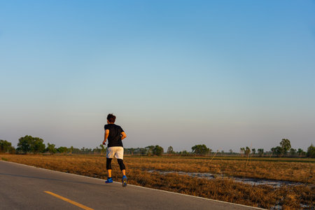 Young fitness asian man is running and jogging an outdoor workout on the road in the morning for lifestyle health.の写真素材