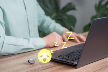 Man put a glowing a light bulb wiht sleepy icon on a wooden table, business problem solving ideas and creative marketing ideas Inventing and learning new things.の写真素材