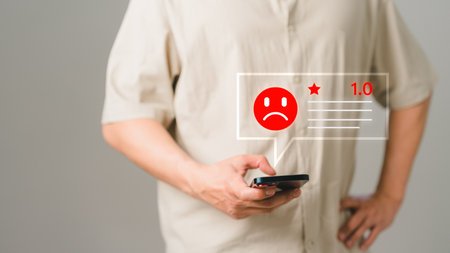 Man client with angry emotion face on virtual screen. Assessment testimonial review for dislike service and low quality. Business service concept of customer experience dissatisfied by smartphone.の写真素材