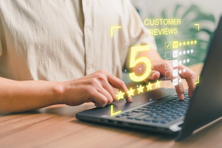 Man hand using a computer laptop with pop up smiley face and five star icon for assessment feedback review satisfaction and testimonial. Customer service experience and business satisfaction survey.の写真素材