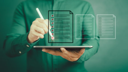 Man using a pen and tablet with touching on virtual screen contact questionnaire with checkboxes. Assessment test concept, fill out application form, online exam, quiz knowledge and online learning.の写真素材
