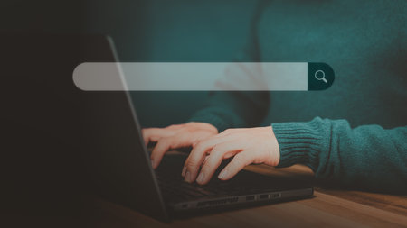 Man hand working with laptop computer on table in his home. Search the Internet with an empty search bar. Best SEO search networking, Searching browsing internet data information concept.の写真素材