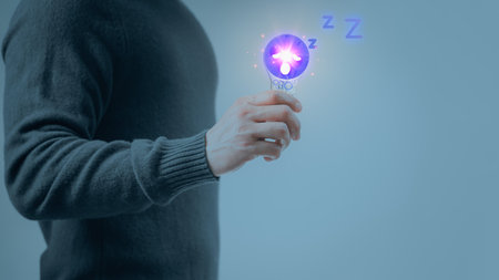 Man hand holding illuminated light bulb wiht sleepy icon, Concepts Tired of solving business problems and creative marketing ideas? Can't invent and learn new things.の写真素材