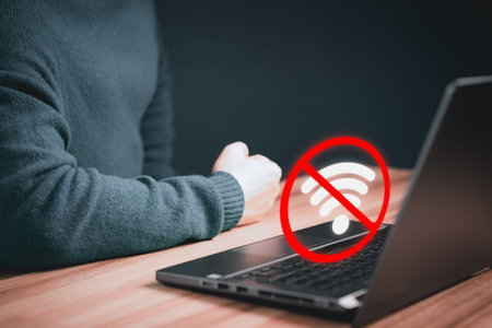 Guy using a computer laptop to connect to wifi in his home but wifi not connected, and waiting to loading digital game data form website, concept technology of waiting for connect to wifi.の写真素材