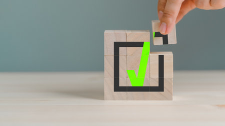 Hand placing wooden cube with green checkmark icon. Goals achievement and business success. Quality and ISO symbol. Do the right thing. Tick and cross signs, approve and disapprove symbol.の写真素材