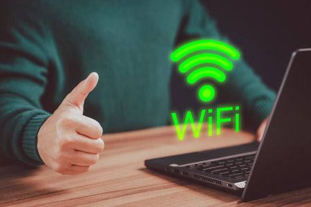 Young man searching for wifi on his a computer laptop in the cafe. Concept of technology connectivity and connection problems to wifi by computer.の写真素材