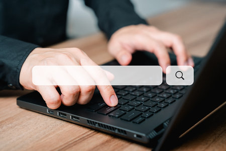 Male hand working with laptop computer on table. Search engine optimization the internet with search bar. Best SEO technology networking, Searching browsing internet data information concept.の写真素材