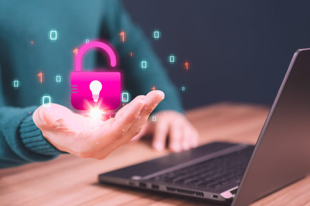 Man showing open key icon with creativity light bulb symbol in hand while working on computer laptop...