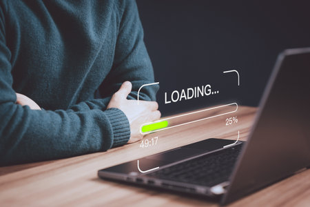 Young man using a laptop computer for download and update software and waiting to loading digital file data form website, very slow internet form wifi. Concept of waiting for load of loading symbol.の写真素材