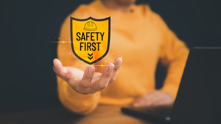 Man showing the safety banner symbol on hand. Concept of safety banner, caution work hazard, danger surveillance, safety first symbol, work safety, zero accident, worker safety awareness at workplace.の写真素材