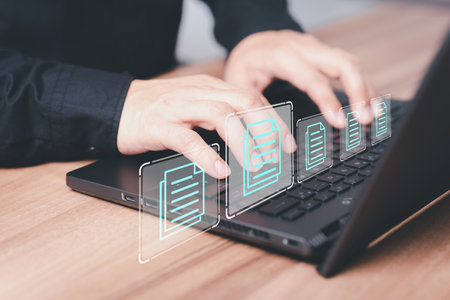 Employee typing on a computer keyboard checking documents in office. Document management concept with icons on ERP virtual screen. Online documentation database to efficiently manage files.の写真素材