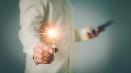 Adult man hand holding illuminated light bulb, creative with glowing light bulb. Inspiration concept of learning, new knowledge and sustainable business development. Innovation and inspiration idea.の写真素材