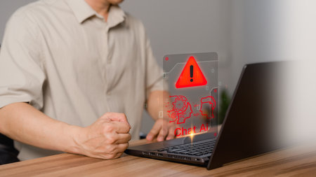 Young man using laptop computer chatting with triangle caution warning sign for notification error concept. Chat with smart AI or Artificial Intelligence technology. Chat bot ai communication.の写真素材