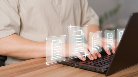 Document management concept with icons on ERP virtual screen. Employee typing on a computer keyboard checking documents in office. Online documentation database to efficiently manage files.の写真素材