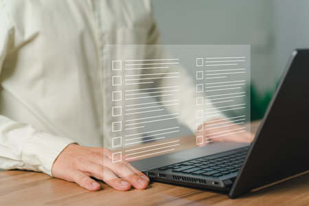 Young man using laptop computer with virtual screen contact questionnaire with checkbox. Assessment knowledge test concept, fill out application form, online exam, quiz knowledge and online learning.の写真素材