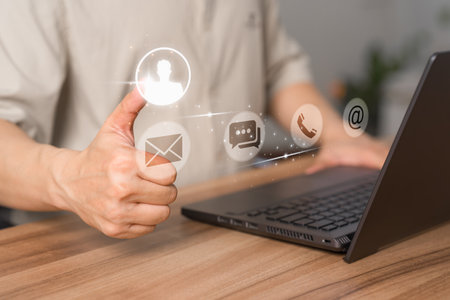 User use a laptop with a virtual screen for apps phones, email, addresses, chat, and message icons. The customer service support hotline contacts us with the people connection technology concept.の写真素材