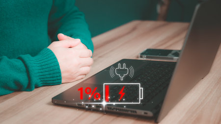 User is angry and frustrated when he learns that his laptop computer's battery is dead and did not bring the charger adapter. Concept of Technology and daily life of freelance. No power battery.の写真素材