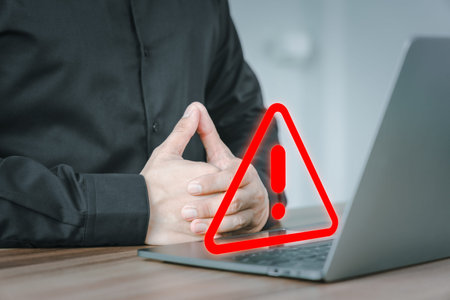 User man using a computer laptop with triangle caution warning sign for notification error. Concept...