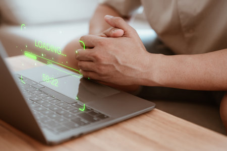 Man use a laptop computer to download and update software with waiting to load digital file data...