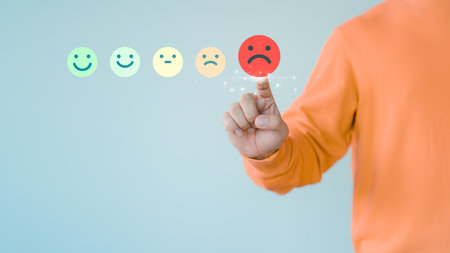 Customer hand touching the virtual screen on the angry emotion face. Assessment testimonial review for dislike service and low quality. Business concept of customer experience dissatisfied.の写真素材