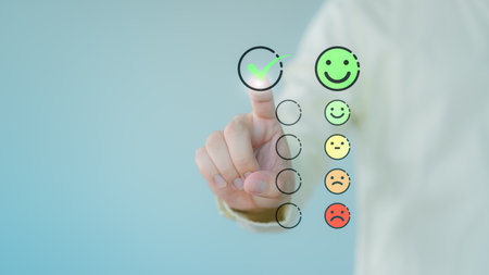 Customer hand touching the virtual screen on happy smile face icon to give satisfaction in service. Business concept of assessment testimonial customer service and feedback, Opinion rating very good.の写真素材