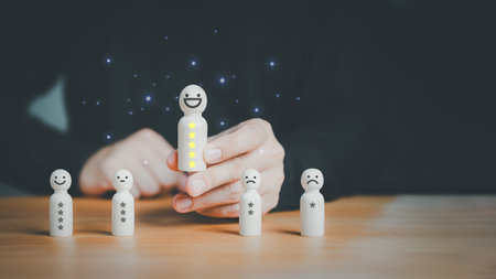 Satisfaction survey concept. User hand chooses a wooden doll with happy smile face. Customer services best excellent business rating experience, testimonial, good review, good feedback.の写真素材