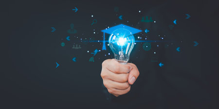 Hand showing graduation hat icon in light bulb. Internet education course degree and study knowledge. Creative thinking idea with goal, laptop, friend. E-learning graduate certificate program concept.の写真素材