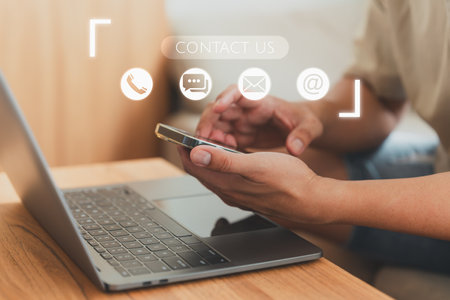 Man using a smartphone with virtual screen member contact icons ( phone, email, address, live chat). Customer service, helpdesk advice online support. Contact us support hotline, people connect.の写真素材
