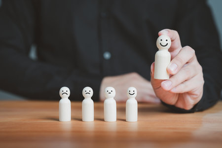 Satisfaction survey concept. User hand chooses a wooden doll with happy smile face. Customer services best excellent business rating experience, testimonial, good review, good feedback.の写真素材