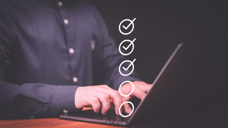 Businessman use a laptop computer to tick correct sign mark in checkbox. Concept of compliance to regulations product, Service, Quality control, Inspection, Standardization, certification.の写真素材