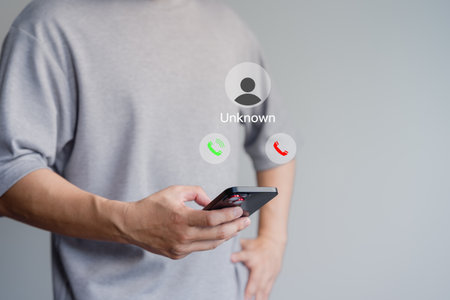 Call center gang or stranger. The phone call was from an unknown number. Hoax person with a fake identity. Concept of scam, fraud with smartphone from the criminal. Guy answering the incoming call.の写真素材