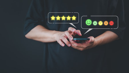 Customer use a smartphone give point 5 stars and smile face icon for feedback review satisfaction service opinion and testimonial on application. Online customer review satisfaction feedback survey.の写真素材