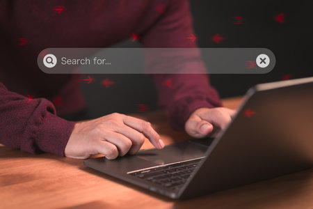 User using a laptop computer clicking internet search bar. SEO technology networking engine optimization internet with search bar. Searching browsing internet data information concept.の写真素材