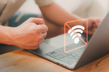 Man using a laptop computer to connect to wifi, but wifi not connected or password is incorrect and waiting to loading digital data form website. Technology concept of wifi connected but no internet.の写真素材