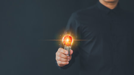 Male hand holding illuminated light bulb. Creative idea, new business plan, motivation, innovation, inspiration. Energy saving light bulb. Concept of new ideas with innovation and creativity.の写真素材
