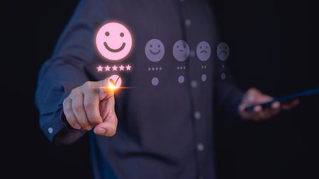 Person selects a happy face with a five-star rating, symbolizing customer satisfaction, feedback, and positive user experience. Concept of conveys quality service evaluation in a digital interface.の写真素材